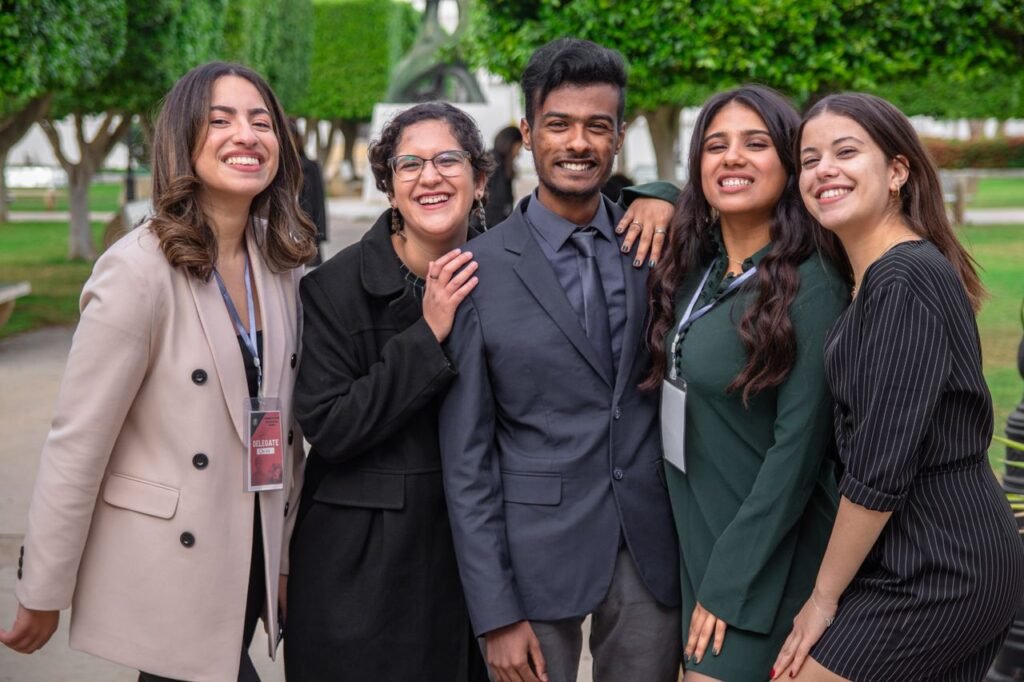 A group of diverse colleagues smiling together, showcasing teamwork and friendship outdoors.